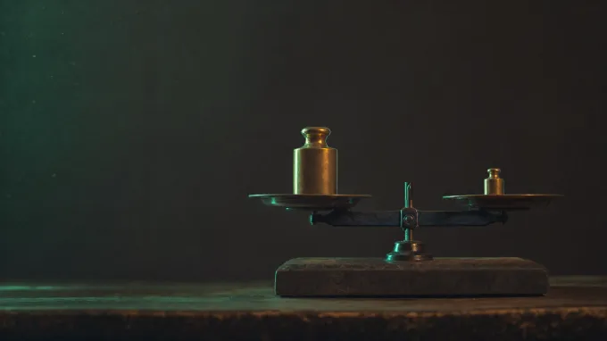 Deux masses étalons, l’une deux fois plus petite, qui font pencher la balance à égalité.